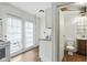 Functional kitchen adjacent to a bathroom, featuring white cabinets and access to the backyard at 3343 Ashley Ln, Indianapolis, IN 46224