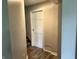 This hallway with laminate flooring and gray paint leads to a staircase at 3525 Lombardy Pl, Indianapolis, IN 46226
