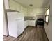 Efficient kitchen features white cabinetry, updated appliances, and luxury vinyl plank flooring at 3525 Lombardy Pl, Indianapolis, IN 46226