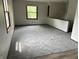 Bright living room featuring neutral walls, new carpet and natural light from large windows at 3525 Lombardy Pl, Indianapolis, IN 46226