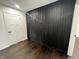 Striking accent wall with vertical black strips adding depth, with beautiful wood flooring at 3962 Graceland Ave, Indianapolis, IN 46208