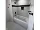 Beautiful bathroom featuring white tile, dark accent stripes, new fixtures and a shower and tub combo at 3962 Graceland Ave, Indianapolis, IN 46208