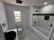 Beautiful bathroom featuring a sleek black sink and new toilet, complimented by a shower and tub combo at 3962 Graceland Ave, Indianapolis, IN 46208