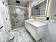 Modern bathroom featuring marble floors, a stylish sink, and a glass-enclosed shower with gold trim at 3962 Graceland Ave, Indianapolis, IN 46208