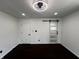 Minimalist bedroom with white walls, dark wood floors, modern lighting, and sliding barn door at 3962 Graceland Ave, Indianapolis, IN 46208