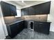 Modern kitchen with black cabinets, stainless wine cooler, grey backsplash and black stone countertops at 3962 Graceland Ave, Indianapolis, IN 46208