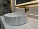 Close up of an elegant bowl sink with gold faucet, lighted mirror, and marble floors at 3962 Graceland Ave, Indianapolis, IN 46208
