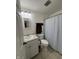 This bathroom has a white vanity, toilet and a shower with a blue striped curtain at 4404 London Ct, Indianapolis, IN 46254
