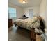 This bedroom has 2 windows, dresser, and an unmade bed with an ugly comforter at 4404 London Ct, Indianapolis, IN 46254