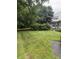This front yard is large and the grass needs to be cut. The home is partially visible at 4404 London Ct, Indianapolis, IN 46254