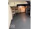 Unfinished basement featuring painted floor, white walls, shelving, and utilities at 4405 Primrose Ave, Indianapolis, IN 46205