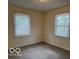 Simple bedroom with two windows and neutral carpet at 4405 Primrose Ave, Indianapolis, IN 46205