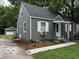 Side view of a quaint one-story home featuring grey siding and a detached garage at 4405 Primrose Ave, Indianapolis, IN 46205