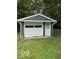 Detached one-car garage with white door and matching trim, nestled in a green yard at 4405 Primrose Ave, Indianapolis, IN 46205
