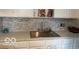 Stylish kitchen counter with white cabinets, marble backsplash, and stainless steel sink at 4405 Primrose Ave, Indianapolis, IN 46205