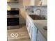 A clean kitchen with stainless steel appliances, light countertops, and wood-look flooring at 4405 Primrose Ave, Indianapolis, IN 46205