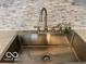 Close-up of a stainless steel kitchen sink with modern faucet and marble backsplash at 4405 Primrose Ave, Indianapolis, IN 46205
