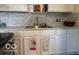 Well-lit kitchen features stainless steel sink, light countertop, and a decorative backsplash at 4405 Primrose Ave, Indianapolis, IN 46205