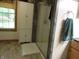 Bright bathroom featuring a glass shower, storage cabinet, and a window with a view of the outdoors at 4521 Tulip N Dr, Martinsville, IN 46151