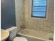 Bathroom featuring tub, toilet, sink, and tiled walls at 4723 Crittenden Ave, Indianapolis, IN 46205