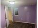 Bedroom features light purple paint, wood-look floors and a door at 4723 Crittenden Ave, Indianapolis, IN 46205
