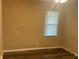 Bedroom with neutral walls, wood-look floors, and a window for natural light at 4723 Crittenden Ave, Indianapolis, IN 46205