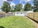 Backyard with a detached white garage, green grass, and wood fence at 5115 Primrose Ave, Indianapolis, IN 46205
