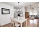 Open dining room showcasing chandelier, wood floors, and view to living room at 5217 Dunewood Way # 3002, Avon, IN 46123