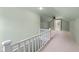 White railing overlooking a spacious attic with neutral carpet, ceiling fan, and natural light at 6030 Evanston Ave, Indianapolis, IN 46220