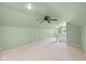 This attic space has neutral carpet, a ceiling fan, and natural light at 6030 Evanston Ave, Indianapolis, IN 46220