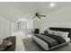 Staged attic space with a comfortable bed, neutral carpet, ceiling fan, and natural light at 6030 Evanston Ave, Indianapolis, IN 46220