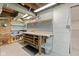 A basement workshop features brick wall, shelving, workbench, tool storage, and painted block wall at 6030 Evanston Ave, Indianapolis, IN 46220