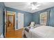 Blue Primary bedroom featuring a ceiling fan, hardwood floors, and natural light at 6030 Evanston Ave, Indianapolis, IN 46220