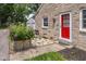 An exterior view shows a stone home, red front door, stone walkway, and tidy landscaping at 6030 Evanston Ave, Indianapolis, IN 46220