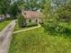 Charming stone cottage-style home with a red front door and lush green lawn and mature trees at 6030 Evanston Ave, Indianapolis, IN 46220
