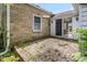 An exterior stone patio features stone wall of the home with window, slider, and foliage at 6030 Evanston Ave, Indianapolis, IN 46220