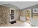 This sunroom offers stone wall, tiled floor, access to the backyard, and natural light at 6030 Evanston Ave, Indianapolis, IN 46220