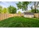 Well-manicured backyard with a new privacy fence, lush lawn, and storage shed at 608 Manhattan Ave, Indianapolis, IN 46241
