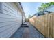 A view of the side yard between two houses featuring a gravel pathway and a new fence at 608 Manhattan Ave, Indianapolis, IN 46241