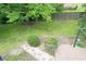 Lush backyard showcases a stone pathway, mature trees, landscaping, and a wood deck at 610 Front Royal Dr, Indianapolis, IN 46227