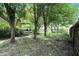 Green backyard with scattered trees offers shade and privacy at 610 Front Royal Dr, Indianapolis, IN 46227