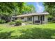 Backyard with a deck, lovely bench swing, and lush greenery at 610 Front Royal Dr, Indianapolis, IN 46227
