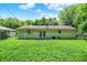 View of the back of the home from the large, grassy backyard with mature trees offering plenty of shade at 6108 Penway St, Indianapolis, IN 46224