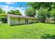 Large backyard with green grass and a view of the home's back exterior featuring a door at 6108 Penway St, Indianapolis, IN 46224
