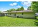 Spacious backyard featuring a lush lawn and the rear of the home with double doors and a small window at 6108 Penway St, Indianapolis, IN 46224