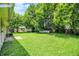 Expansive backyard with a mix of green grass and mature trees providing ample shade and privacy at 6108 Penway St, Indianapolis, IN 46224