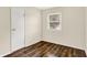 This cozy bedroom features wood-look flooring, neutral walls, a window, and a closet at 6108 Penway St, Indianapolis, IN 46224