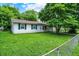Charming home with well-maintained lawn, mature tree, and a fenced yard at 6108 Penway St, Indianapolis, IN 46224