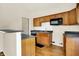 Kitchen with wood cabinets, granite countertops, stainless steel appliances, and breakfast bar at 6108 Penway St, Indianapolis, IN 46224