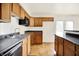 Well-lit kitchen features wood cabinets, black appliances and countertops, and stainless steel sink at 6108 Penway St, Indianapolis, IN 46224
